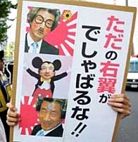 Protestor in Tokyo carries a sign of Koizumi that reads -Mind Your Own Business, Rightist!