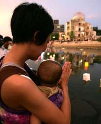 A mother prays with her child in Hiroshima's Peace Park, August 6th, 2005